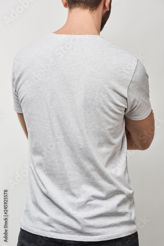 back view of man in basic white t-shirt with copy space isolated on grey