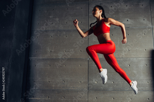 Young fit woman jumping while running Fitness sport girl exercising.