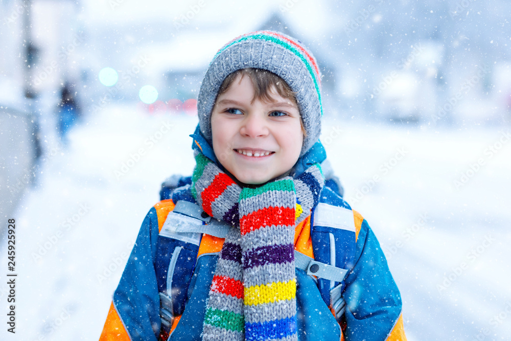 Happy kid boy having fun with snow on way to school Happy kid boy having fun with snow on way to school