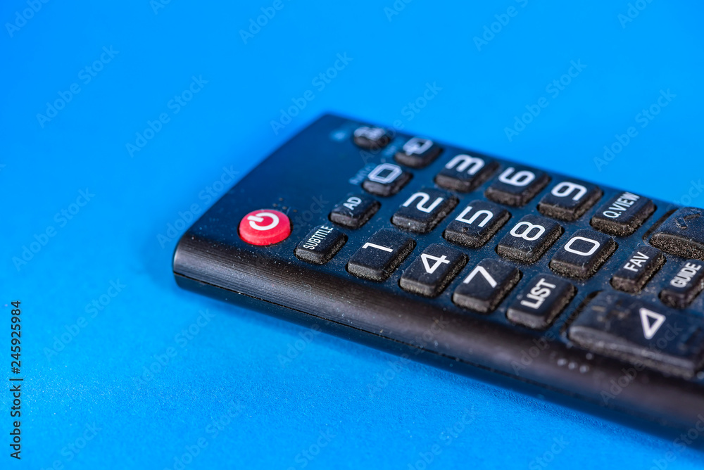 Obraz premium Part of old dirty tv remote console isolated on blue background