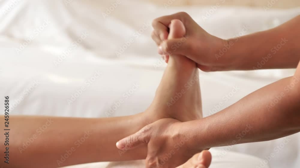 Young woman lying on the bed getting Foot, leg massage in spa salon. massage for health, relaxing. 4k video Slow motion Young woman lying on the bed getting Foot, leg massage in spa salon. massage for health, relaxing. 4k video Slow motion