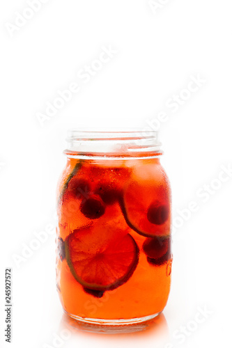 Red cocktail with cherry and lime in jar isolated on white background. Selective focus. Shallow depth of field.