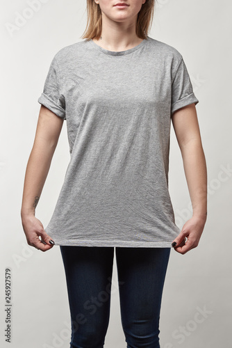 cropped view of young woman in grey t-shirt with copy space isolated on white