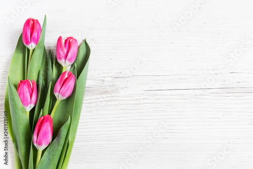 Beautiful pink tulips on wooden background.