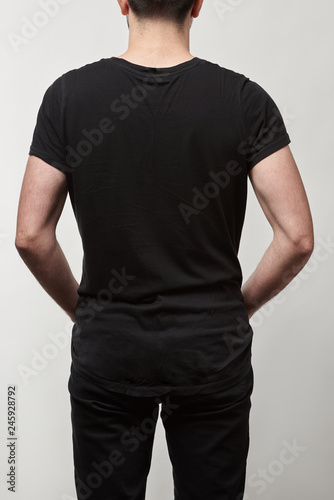 back view of man in black t-shirt with copy space isolated on grey
