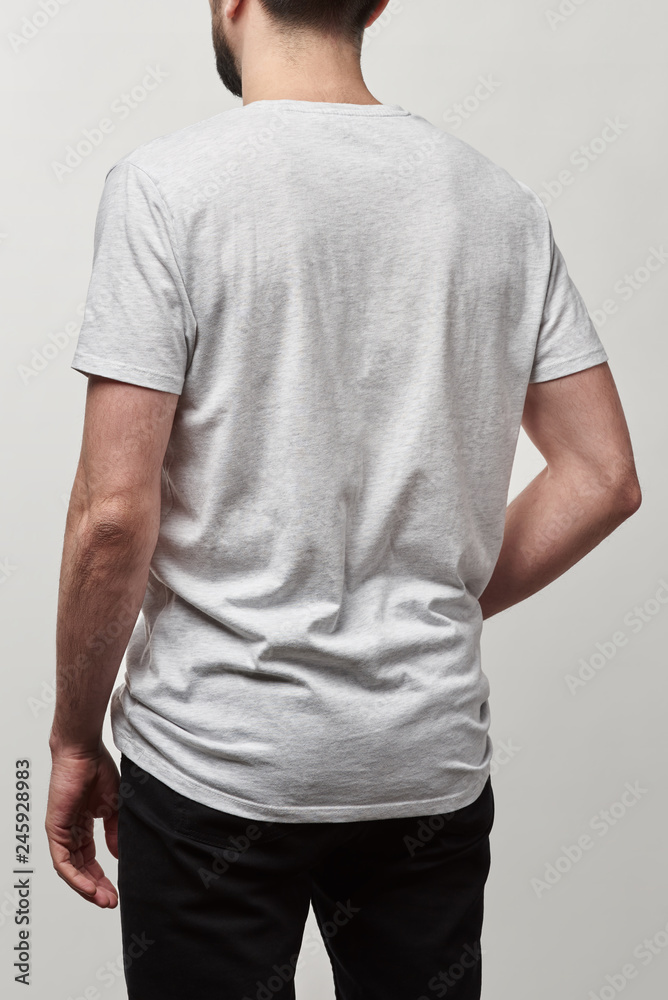 back view of man in white t-shirt with copy space isolated on grey back view of man in white t-shirt with copy space isolated on grey