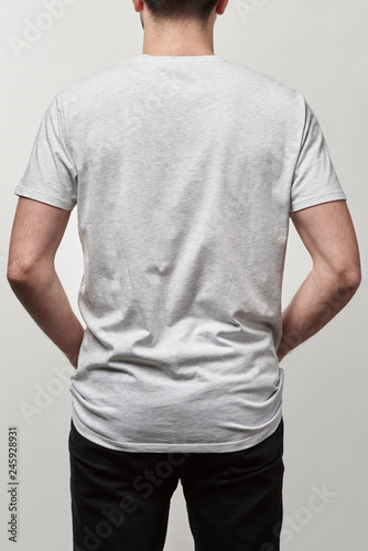 back view of man in casual white t-shirt with copy space isolated on grey