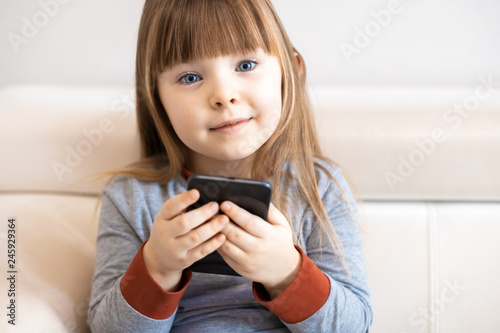 Cute little girl using smart phone