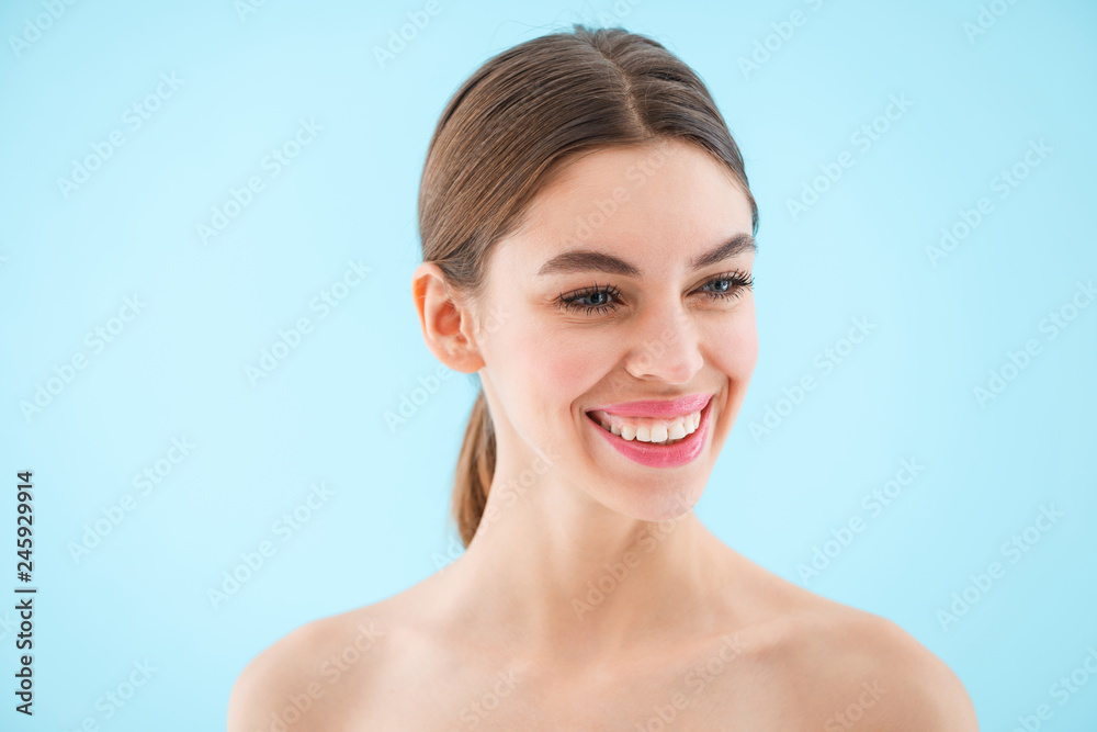 Happy cheerful beautiful young woman posing isolated over blue background. Happy cheerful beautiful young woman posing isolated over blue background.