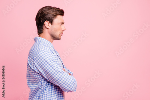 Close up side profile photo of listening frowning attractive he him his man to empty space arms crossed want understand all details wearing casual shirt outfit isolated on pale rose background photo