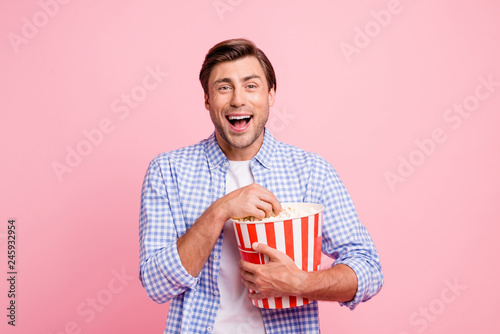 Close up photo of beautiful amazing brunet he him his handsome holding pop corn laughing on favorite tv show wearing specs casual checkered plaid shirt outfit isolated on rose background