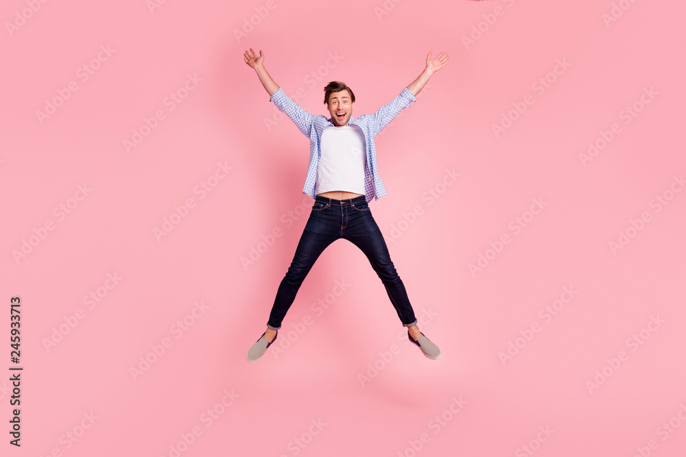 Full length body size photo of jumping high crazy cheer he his him handsome happy glad really need celebrating friday night wearing casual jeans checkered plaid shirt isolated on rose background