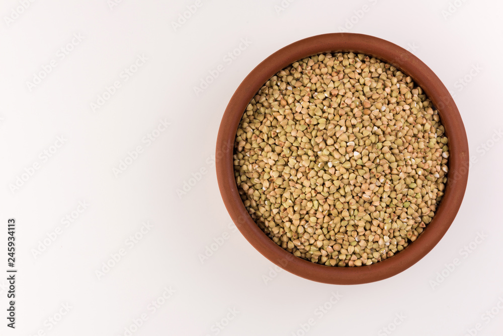 Natural fresh green buckwheat in clay bowl isolated on white background. Natural fresh green buckwheat in clay bowl isolated on white background.