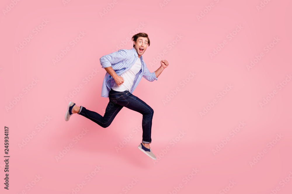 Full length side profile body size photo of jumping high he his him handsome run fast look oh yeah yes expression rushing wearing casual jeans checkered plaid shirt isolated on rose background Full length side profile body size photo of jumping high he his him handsome run fast look oh yeah yes expression rushing wearing casual jeans checkered plaid shirt isolated on rose background