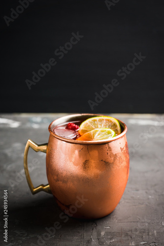 Photography Sweet moscow mule with lime and raspberry in copper mug on the rustic background