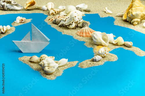 Paper ship worth saving Italy. Map of Italy and the islands are laid out of sand and shells. 