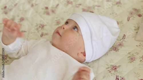 A cute newborn baby is lying on the bed in the bedroom. Portrait of a newborn four-month-old child on a white background. The view from the top. photo