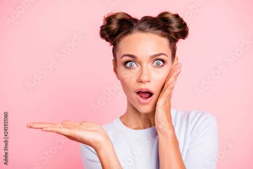 Close-up portrait of her she nice cute attractive lovely cheerful cheery shocked girl lady holding object on palm isolated over pastel pink background