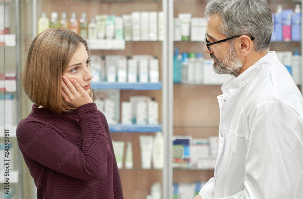 Pharmacist helping woman with tooth ache. Pharmacist helping woman with tooth ache.