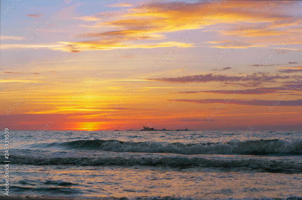 Sunset over the sea. Reflection of sunlight in the sea waves. Red and yellow sky in the rays of the sunset. Sunset over the sea. Reflection of sunlight in the sea waves. Red and yellow sky in the rays of the sunset.