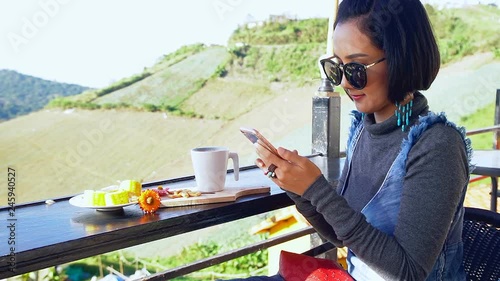 Asian Woman Chatting and Drinking Coffee in Coffee Shop at Mountain Outdoor Landscape