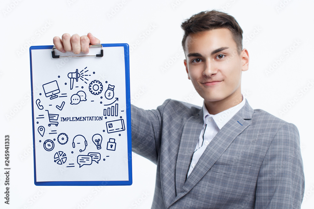 Business, technology, internet and networking concept. Young entrepreneur showing keyword: Implementation Business, technology, internet and networking concept. Young entrepreneur showing keyword: Implementation