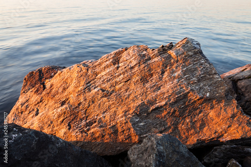 Rocks in lake shore at sunset landscape