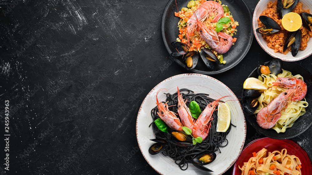 A set of seafood dishes on a black background. Pasta, bulgur, rice, couscous. Top view. Free space for your text.