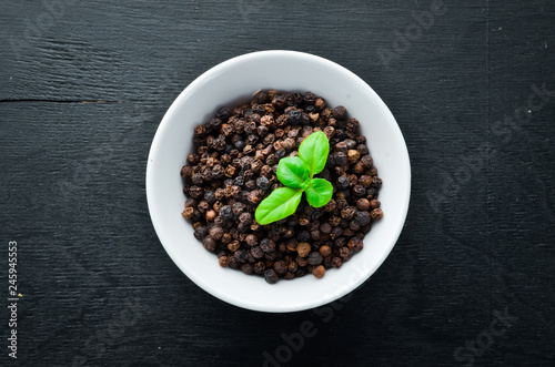 Black pepper peas. Spices Top view. On the old background.