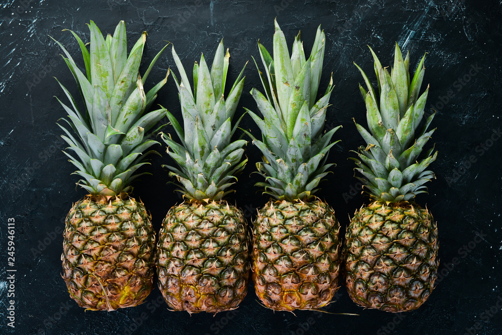 Fresh pineapple on a black stone background. Top view. Free copy space. Fresh pineapple on a black stone background. Top view. Free copy space.