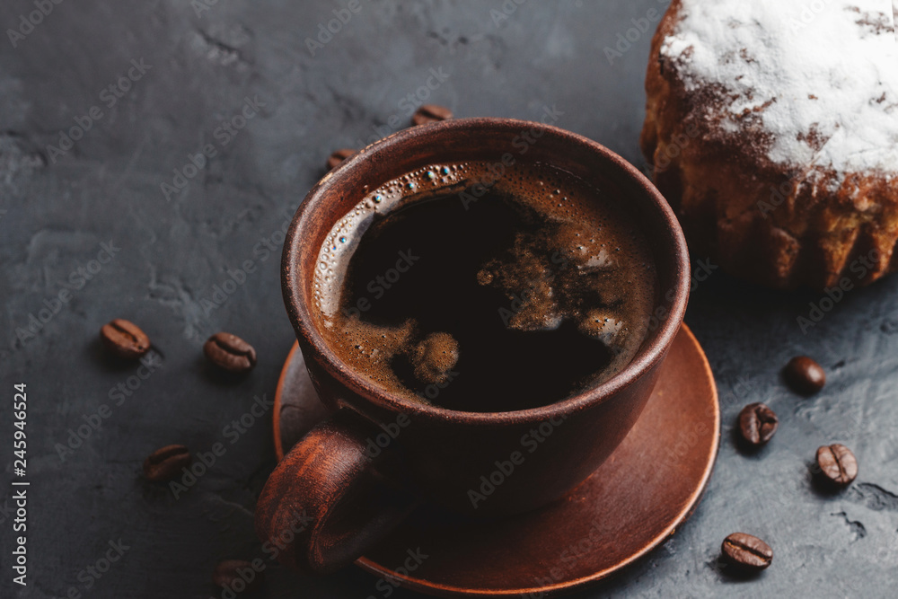 Coffee cup and muffins on the dark, textured background