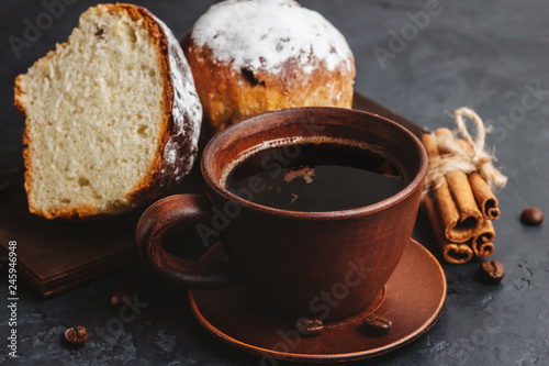 Cup with hot coffee  muffins and cinnamon sticks on the dark  textured background
