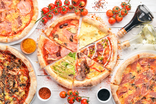 A set of Italian pizza. Italian cuisine. On a white wooden background. Free copy space. Top view.