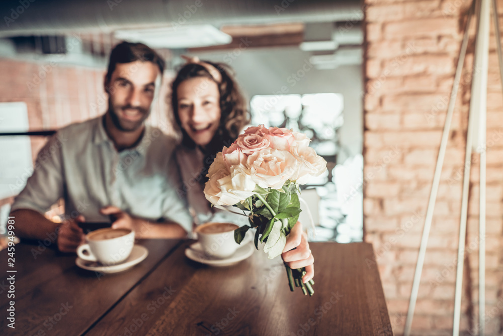 Portrait of beautiful emotional woman with bouquet flowers. Her husband holding hand when they climb the stairs of the restaurant. Portrait of beautiful emotional woman with bouquet flowers. Her husband holding hand when they climb the stairs of the restaurant.