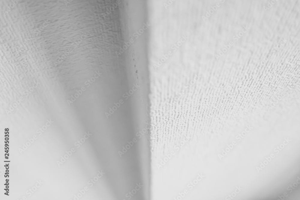 Roughness texture White wallpaper on the wall at a different angle. An ...