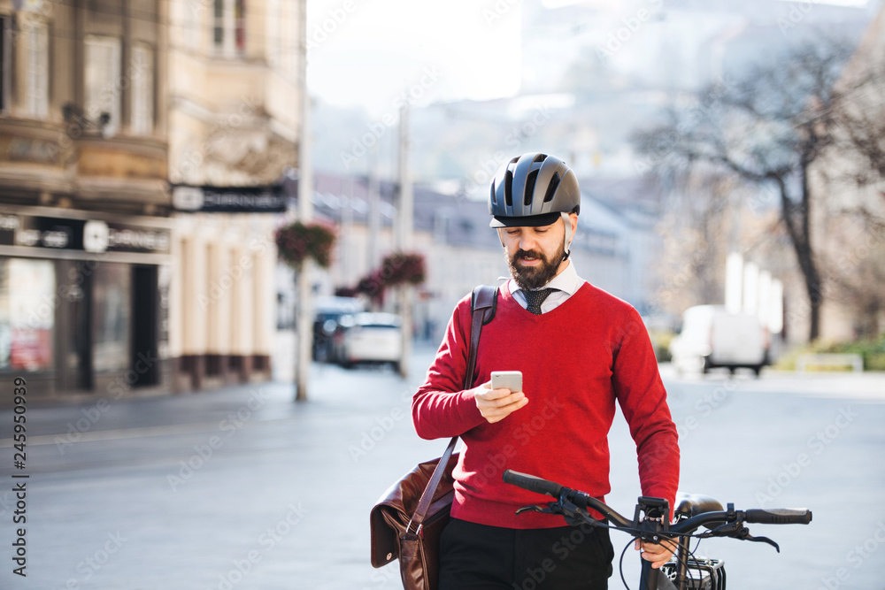 Hipster businessman commuter with bicycle and smartphone on the way to work in city. Hipster businessman commuter with bicycle and smartphone on the way to work in city.