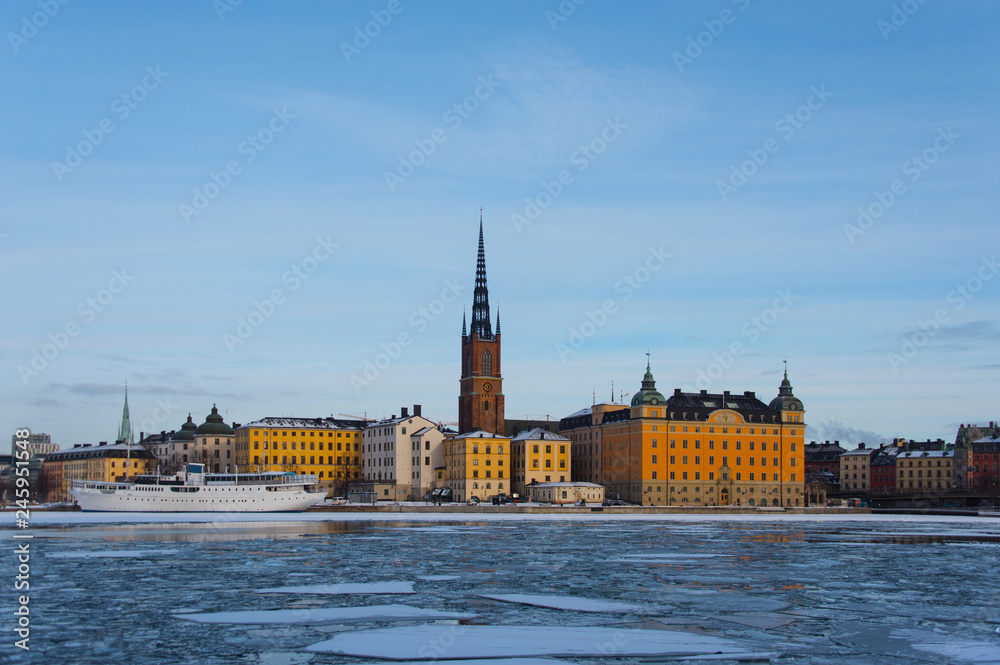 Winter view of Riddarholmen and a frozen lake Malaren in Stockholm in pale light. 