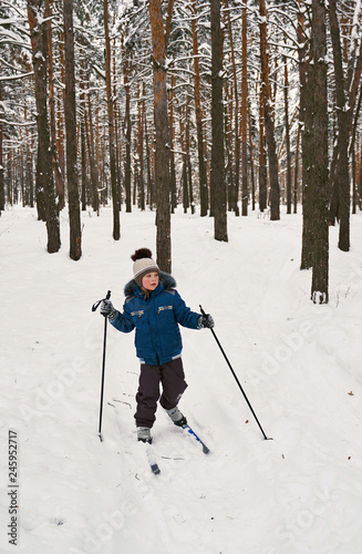 kid skiing in winter forest