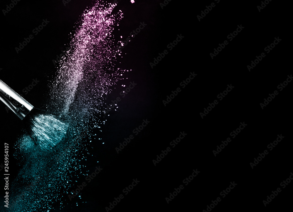 Obraz premium Cosmetic brush with purple and blue ocean cosmetic powder spreading for makeup artist or graphic design in black background