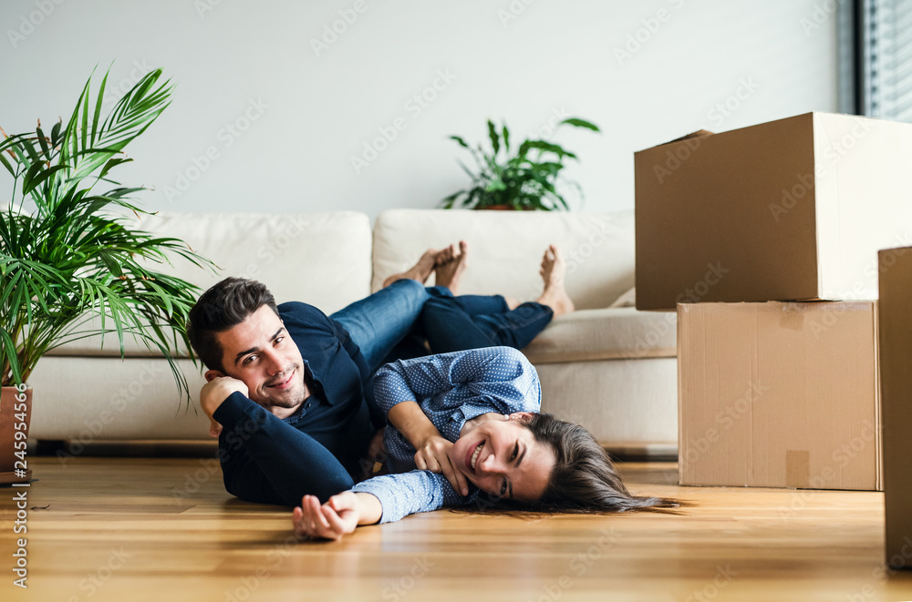 A young couple with cardboard boxes moving in a new home. A young couple with cardboard boxes moving in a new home.