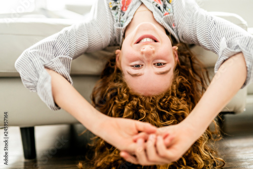 Positive redhead teenage girl lying on a couch.