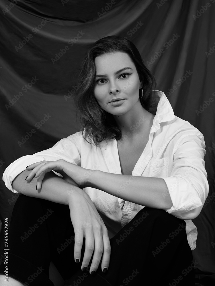 Naklejka premium Attractive Sensual Woman is Posing in White Shirt. Black and White Cinematic Portrait with Cute Emotions