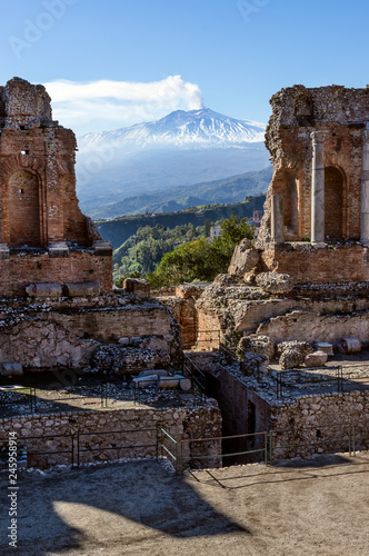 Volcano Etna seen through ruins of ancient Greek amphitheater in Taormina in Sicily