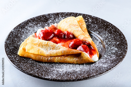 Sweet tasty crepe with strawberry on light background