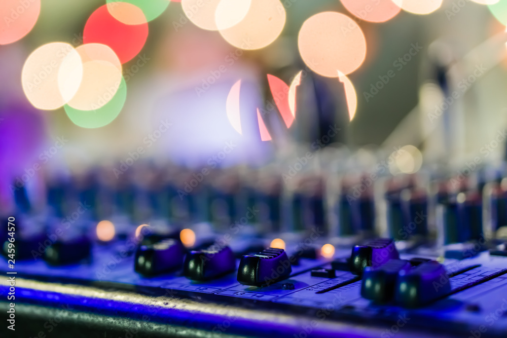 Фотография Selective focus on knops of electronic sound mixer in the foreground of the outdoor party music with bokeh