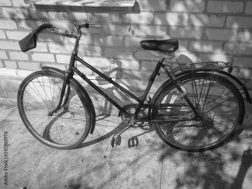 Old retro bicycle on brick wall. Photo in black and white style