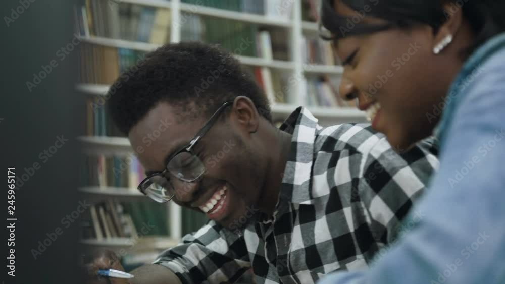 Young african couple preparing to the exams in the library. Young african couple preparing to the exams in the library.