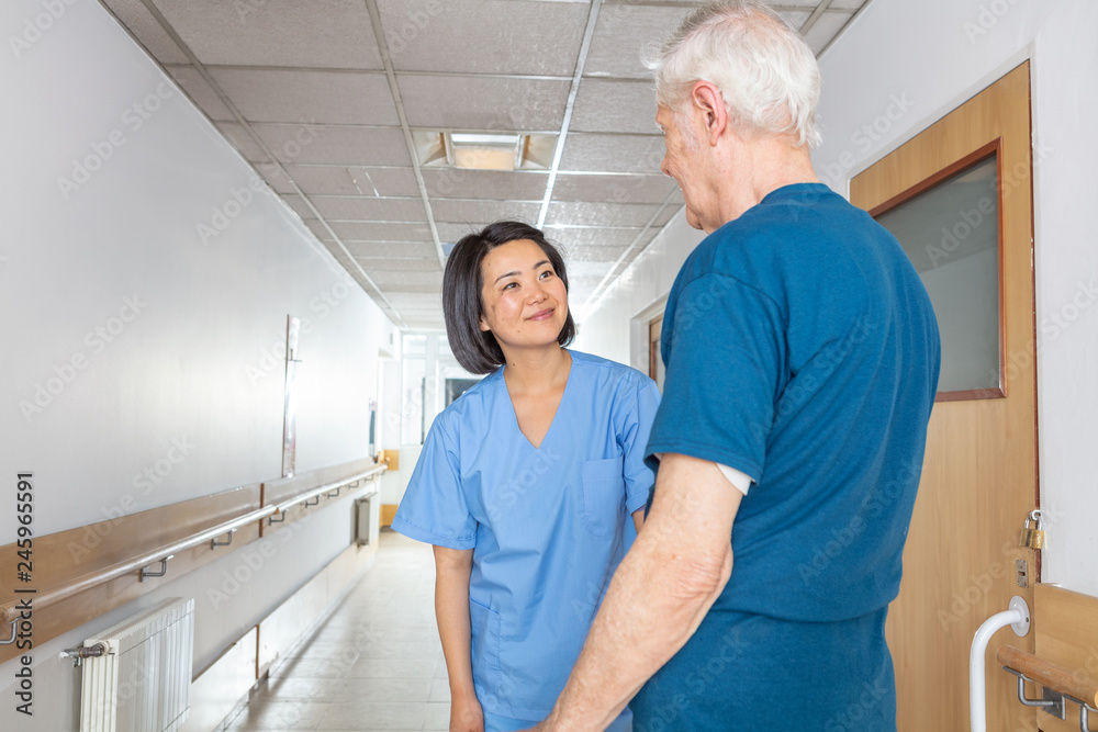 Obraz premium Smiling nurse with elderly man in a nursing home