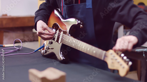 Fotografie Guitarist tuning guitar tuning keys