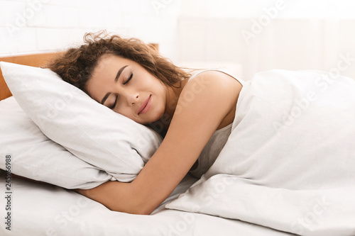 Young woman sleeping in bed in morning